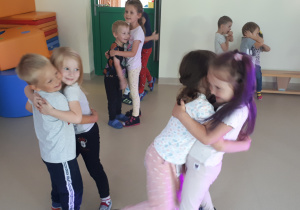 Dzieci przytulają się do siebie tańcząc w parach.