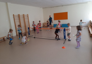 Dzieci uczestniczą w zabawie ruchowej z piłeczkami tenisowymi.