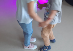 Dziewczynka i chłopiec tańczą w parze.