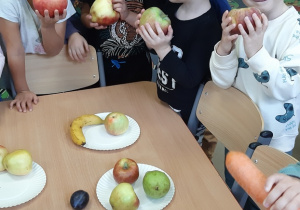 Dzieci trzymają w ręku jabłka