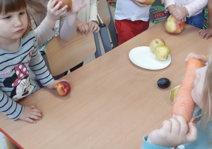 Kilkoro dzieci trzyma w ręku owoce