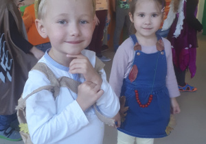 Przebrani w stroje chłopiec i dziewczynka uśmiechają się do zdjęcia