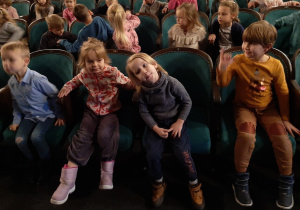 Dzieci siedzą na widowni teatru