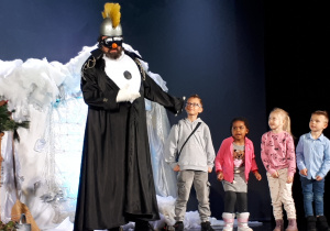 Dzieci stoją na scenie z aktorem