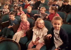 Grupa dzieci siedzi na widowni teatru