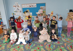 Dzieci pozują do zdjęcia, pokazując swoje pluszowe misie