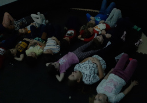 Dzieci leżą na macie piankowej w środku Kina Sferycznego