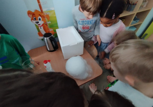 Dzieci obserwują eksperyment z suchym lodem