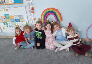 Jubilaci pozują do zdjęcia na tle piniaty urodzinowej