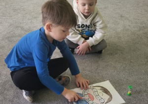 Chłopiec myje zęby narysowane na planszy.