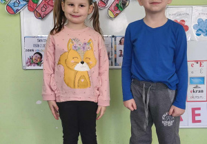 Chłopiec i dziewczynka stoją pod girlandą skarpet.