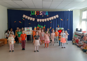 Grupa dzieci śpiewa piosenkę o Marchewce.