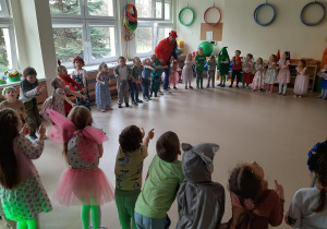 Dzieci ustawione w dużym kole biorą udział w zabawie muzycznej.