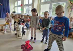 Pies bawi się z dziećmi.