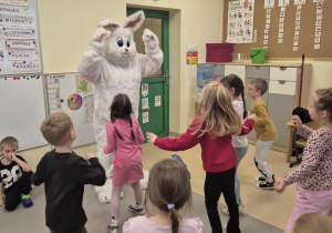 Dzieci tańczą z wielkanocnym zającem.