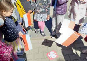 Dzieci pozują przy ułożonym obrazku godła Polski