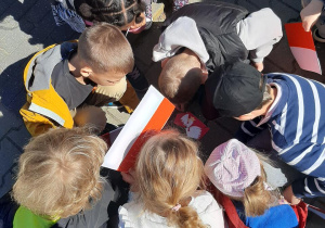 Dzieci układają pocięty obrazek godła Polski