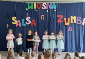 Dzieci pozują do zdjęcia z nagrodami za występy