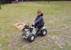 Chłopiec jedzie mini traktorkiem