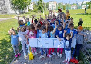Dzieci zakończyły bieg i pozują przy mecie.