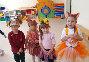 Kilkoro dzieci pozuje do zdjęcia w strojach jesiennych