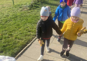 Dzieci wracają z liśćmi do przedszkola.