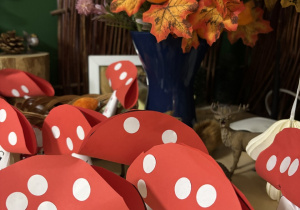 Przestrzenne prace z papieru wykonane przez dzieci przedstawiające muchomory.