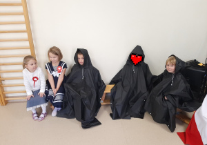 Dzieci siedzą na ławce pozują do zdjęcia