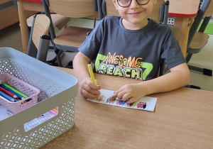 Chłopiec koloruje kredki