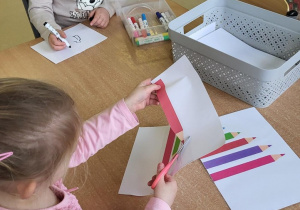 Dziewczynka wycina kredki