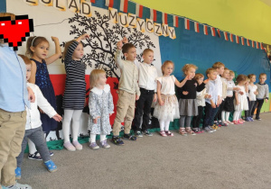 Dzieci ustawione w szeregu śpiewają piosenkę o Polsce