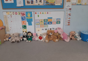 Pluszaki Misie ustawione w szeregu pod ścianą