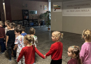 Dzieci idą szkolnym korytarzem