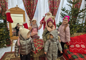 Dzieci pozują do zdjęcia w pokoju Mikołaja.
