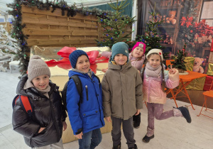 Dzieci pozują do zdjęcia z prezentem.