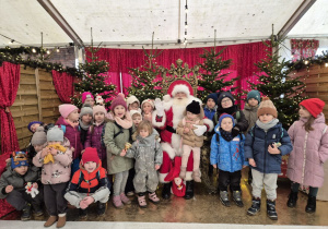 Dzieci pozują do zdjęcia z Mikołajem.
