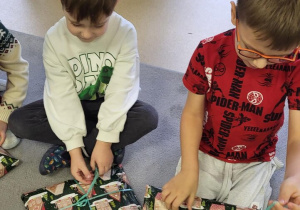 Dwóch chłopców rozpakowuje prezenty świąteczne