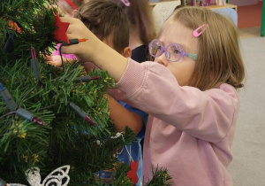 Dzieci ubierają choinkę w klasie