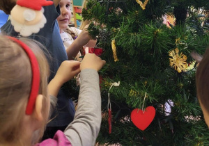 Dzieci ubierają choinkę w klasie