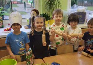 Dzieci pozują z wałkami w dłoni, jeden chłopiec ma czapkę kucharską