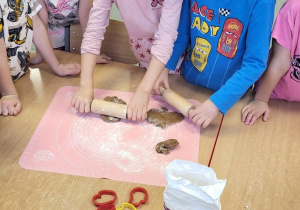 Dzieci wałkują ciasto na pierniczki