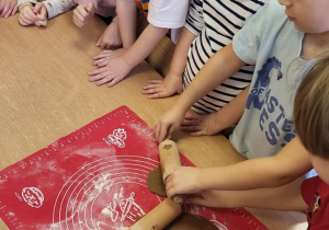 Dzieci wałkują ciasto na pierniczki