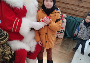 Chłopczyk pozuje do zdjęcia z Mikołajem