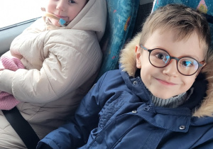 Chłopiec i dziewczynka siedzą w autokarze.