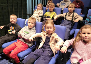 Dzieci siedzą na widowni w teatrze.