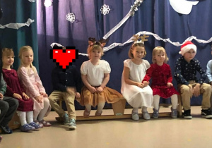 Na ławeczce sziedzą dzieci i czekają na wysęp.