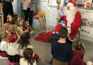 Święty Mikołaj rozdaje dzieciom prezenty