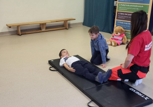 Chłopcy uczą się jak położyć człowieka w pozycji bocznej bezpiecznej