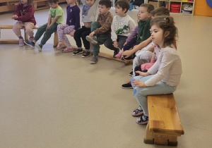 Dzieci siedzą na ławkach podczas warsztatów z pierwzej pomocy