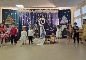 Grupa dzieci, dwoje przebranych za Maryję i Józefa, pozostałe w strojach postaci z bajek.